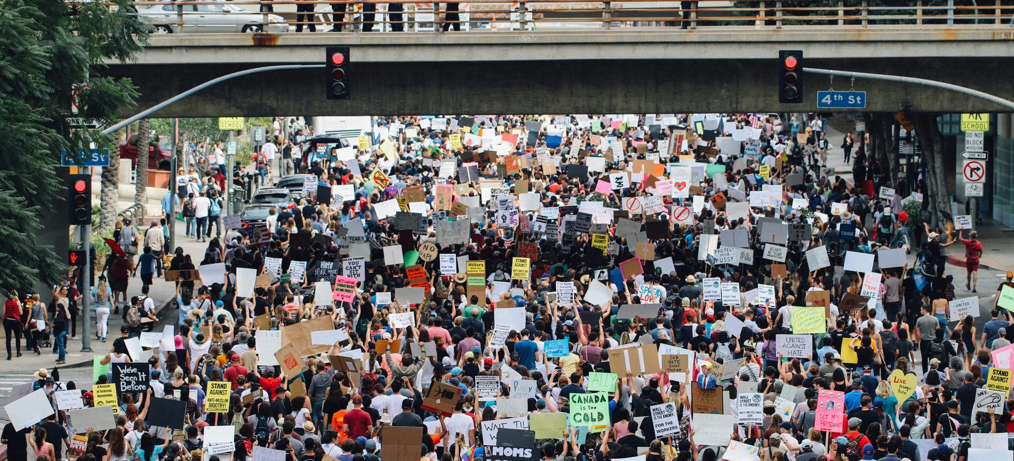 A large crowd marching through city streets in protest